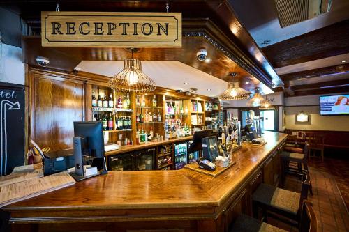a bar in a pub with a sign that reads reception at Red Lion, Wigan by Marston's Inns in Rufford