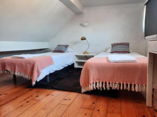 twee bedden in een kamer met houten vloeren bij Inglesinhos Loft in Lissabon