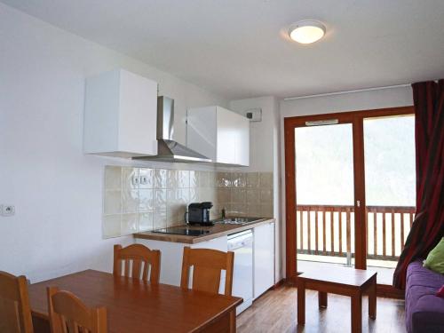 une cuisine et une salle à manger avec une table et une salle à manger gmaxwell gmaxwell gmaxwell gmaxwell dans l'établissement Appartement 4 pers avec piscine, jacuzzi et balcon, proche des pistes - Les Orres - FR-1-322-421, aux Orres