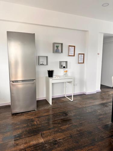 uma cozinha com um frigorífico de aço inoxidável e uma mesa em Aphrodites Suite em Pafos