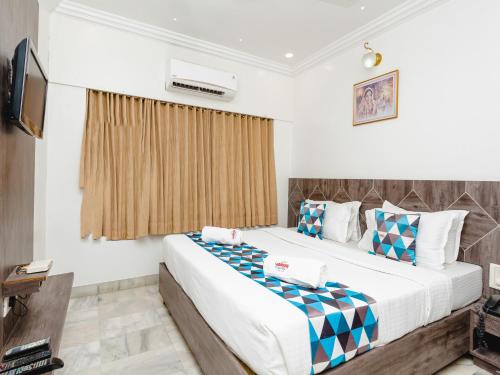 a bedroom with a large bed and a television at Hotel Galaxy Opp Surat Railway Station in Surat