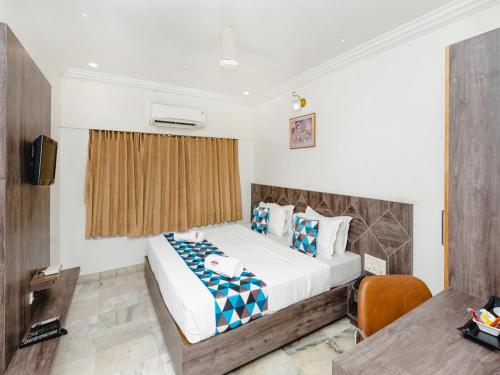 a hotel room with a bed and a desk at Hotel Galaxy Opp Surat Railway Station in Surat