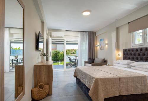 ein Hotelzimmer mit einem Bett und einem Balkon in der Unterkunft Astra Sarti Luxury Suites in Sarti