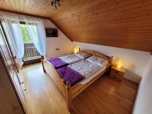 Cama en habitación con techo de madera en Haus Seebrise, en Faak am See