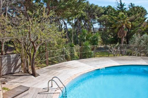 - une piscine dans une cour avec une clôture et des arbres dans l'établissement Château le Bouïs, à Gruissan