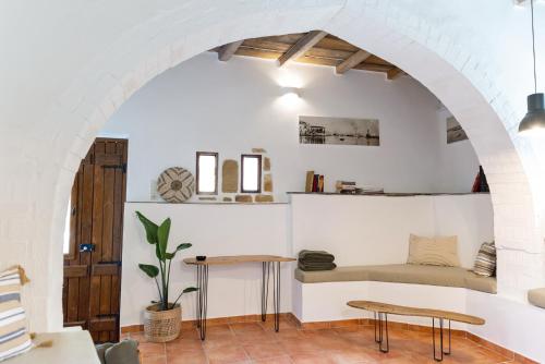 a room with an archway with a bench and tables at Tethys 3 by Cretan Pnoe Adults Only in Kolymvari