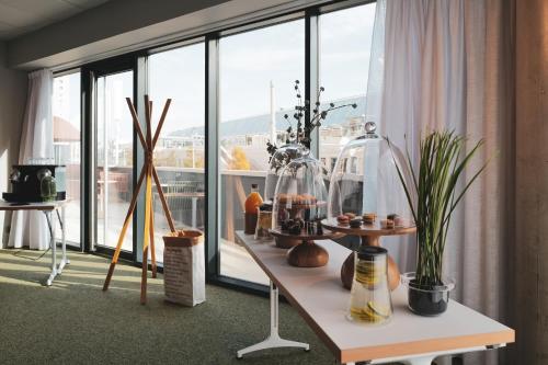 Cette chambre dispose d'une table avec des plantes et d'une fenêtre. dans l'établissement Belaroïa Montpellier Centre Saint Roch, à Montpellier