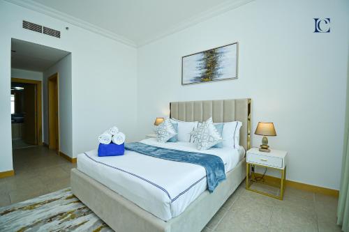 a bedroom with a white bed and a nightstand and a bed sidx sidx sidx at Palm Jumeirah's Spectacular Ocean-View Apartment - NBT in Dubai