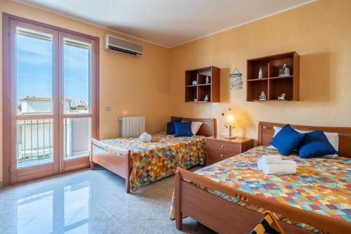 a bedroom with two beds and a balcony at Casa Vacanza Germano - Vivi un soggiorno da sogno - 160m2 di comfort e vista mare in Sicilia! in Pachino