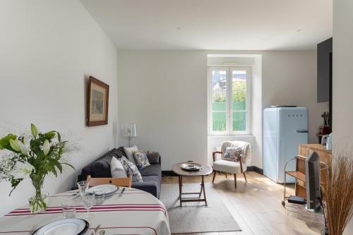 un soggiorno con divano e frigorifero blu di Ti Massa - Petit cocon avec jardin à St Servan a Saint Malo