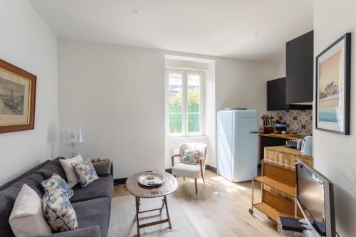 - un salon avec un canapé et un réfrigérateur dans l'établissement Ti Massa - Petit cocon avec jardin à St Servan, à Saint-Malo