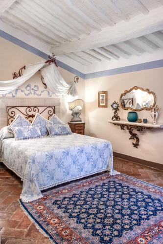 a bedroom with a bed with a blue and white bedspread at Il Falconiere Relais & Spa in Cortona