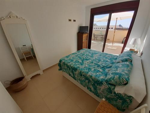 1 dormitorio con cama y vistas a un balcón en Apartamento en Águilas con amplia terraza y piscina, en Águilas