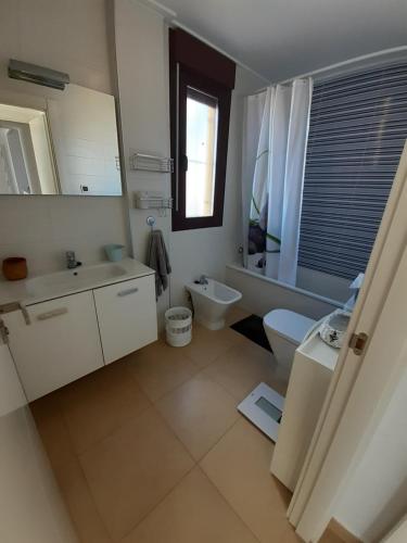 a white bathroom with a sink and a toilet at Apartamento en Águilas con amplia terraza y piscina in Águilas