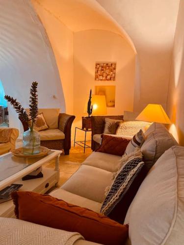 un salon avec un canapé et une table dans l'établissement Aux quatre Voûtes, à Saint-Marcel-dʼArdèche