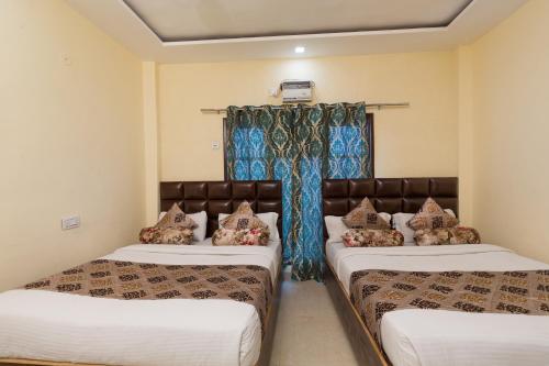 a bedroom with two beds and a window at The Nirvana By Urban Galaxy in Amritsar