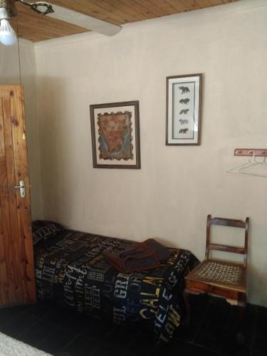 a bedroom with a bed and a chair at umbabala bush camp in Rustenburg