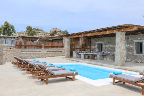 a villa with a swimming pool and lounge chairs at The George Villas Mykonos with Private Pool & Town Proximity in Mýkonos City