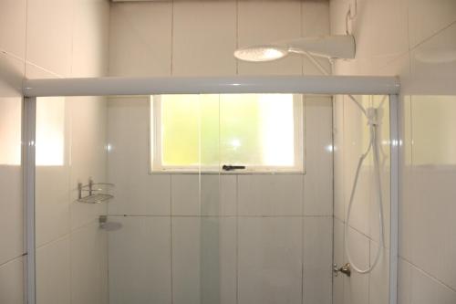 a bathroom with a shower with a window and a glass door at Casa Ourinhos Pet Friendly in Ourinhos