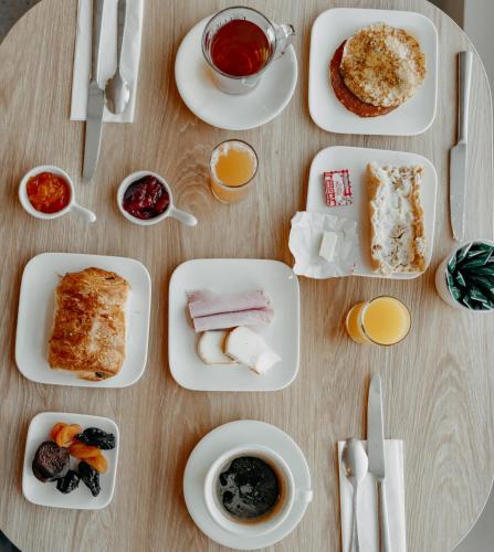 a table with plates of food and cups of coffee at Hôtel Le Rivage vue sur mer - Châtelaillon-plage in Châtelaillon-Plage