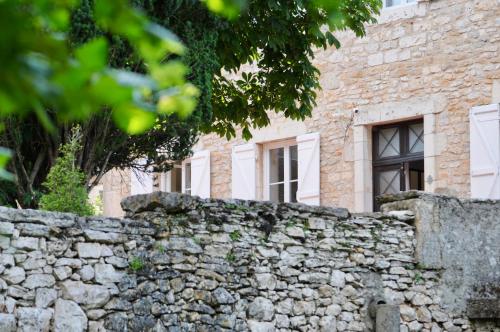 a stone wall in front of a building at Maison Balmelle - Maison d'hôtes de Caractère in Gramat