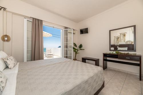 a bedroom with a bed and a view of the ocean at Mouria Studios & Apartments in Laganas
