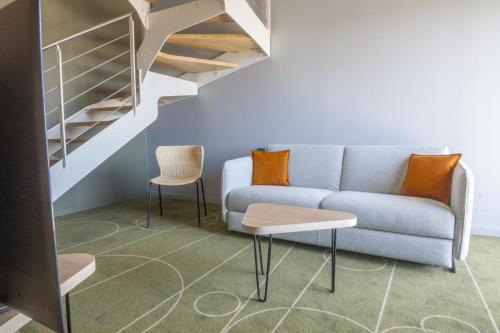 a living room with a couch and a staircase at Belaroïa Montpellier Centre Saint Roch in Montpellier