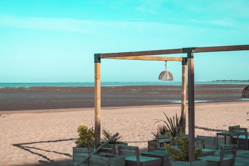 a tent on the beach with a view of the beach at Hôtel Le Rivage vue sur mer - Châtelaillon-plage in Châtelaillon-Plage