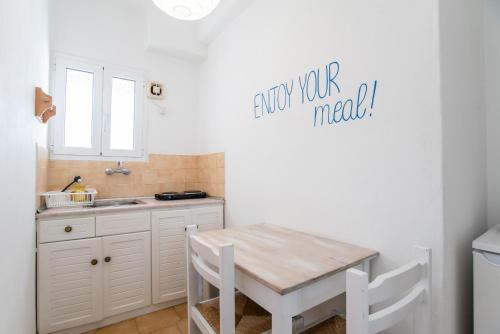 a small kitchen with a table and a sink at Livadia Seaside Studios 14 in Parikia