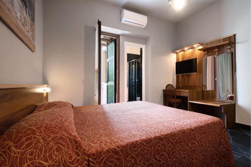 a bedroom with a bed and a desk and a window at Residence Paradiso Bilocale 303 in Moneglia