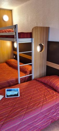 - une chambre avec 2 lits superposés et un livre dans l'établissement Premiere Classe Bayeux, à Bayeux