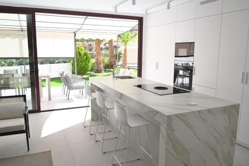 a kitchen with a large island with stools at The Royal Garden by LUCIA DE SU in Santa Cruz de Tenerife