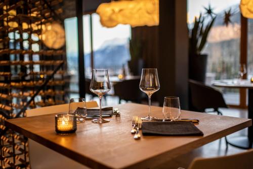 a table with two glasses of wine on it at Hotel Arnica Scuol - Adults Only in Scuol