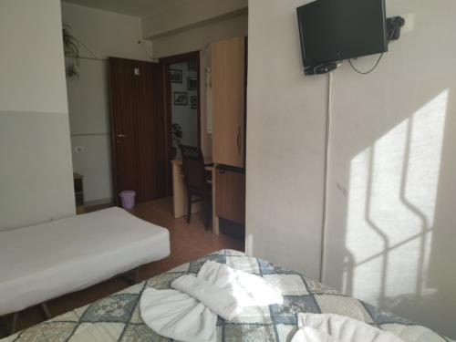 a room with a bed and a tv in it at Guest House De Rada in Tirana