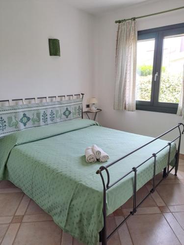 a bedroom with a bed with two towels on it at Sa Domixedda in Villasimius