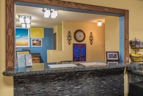 - une vue sur un comptoir de restaurant avec une horloge dans un miroir dans l'établissement Days Inn by Wyndham Tucumcari, à Tucumcari