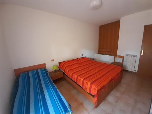 Un dormitorio con una cama roja y azul. en Le Arselle en Principina a Mare