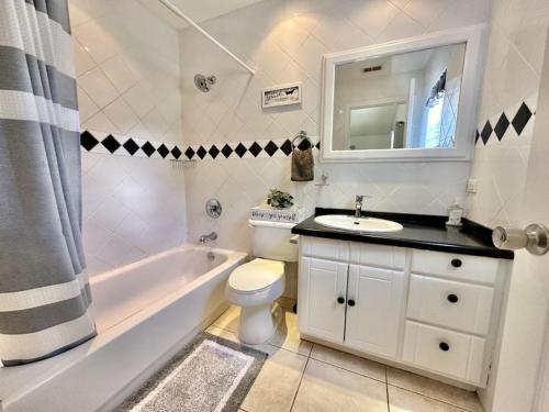 a bathroom with a sink and a tub and a toilet at Villa Utopia in Jolly Harbour