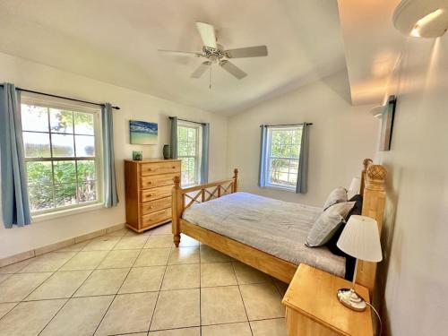 a bedroom with a bed and a ceiling fan at Villa Utopia in Jolly Harbour