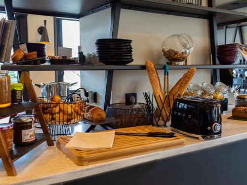 a kitchen counter with bread and baskets of food at Mercure Lorient Centre in Lorient