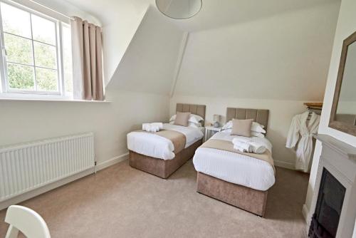 two beds in a room with a fireplace at Secluded holiday cottage near the Wolds Way 