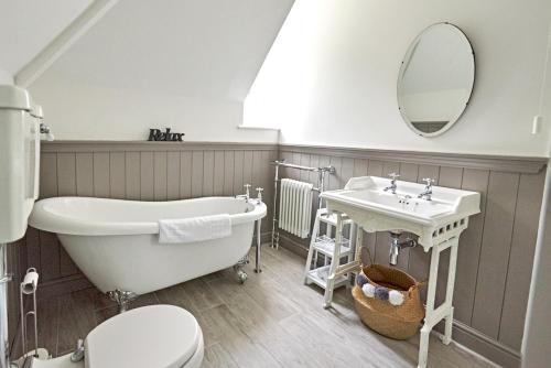 ein Badezimmer mit einer Badewanne, einem Waschbecken und einem WC in der Unterkunft Secluded holiday cottage near the Wolds Way 