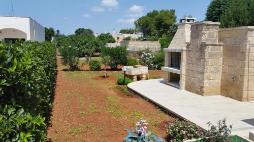 a garden with a stone building and a yard at La Torre in Torre Suda