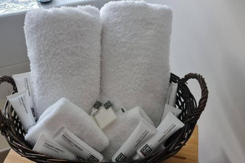 a basket filled with towels and toothbrushes at Sojourn on Stewart - Mansfield House with Spa Bath in Mansfield