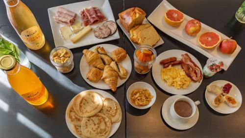 a table topped with plates of breakfast foods and drinks at Best Western Plus Le Moderne in Caen