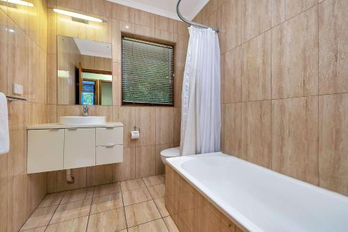 La salle de bains est pourvue d'une baignoire blanche et d'un lavabo. dans l'établissement Comfort Inn & Suites Sombrero, à Adélaïde