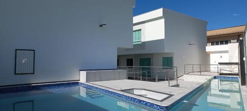 una piscina frente a un edificio en APT DUPLEX BEST BIGGEST ENCANTOS de TAPERAPUAN a 100 M da PRAIA, en Porto Seguro