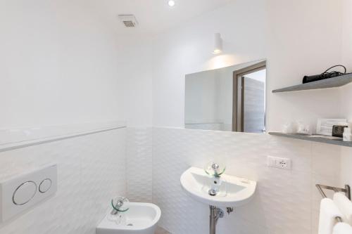 a white bathroom with a sink and a toilet at Hotel San Michele in Celle Ligure
