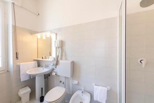 a white bathroom with a toilet and a sink at Hotel San Michele in Celle Ligure