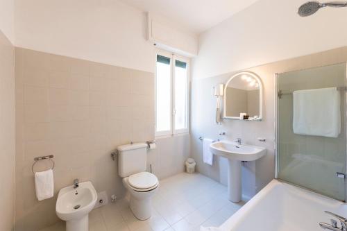 a white bathroom with a toilet and a sink at Hotel San Michele in Celle Ligure